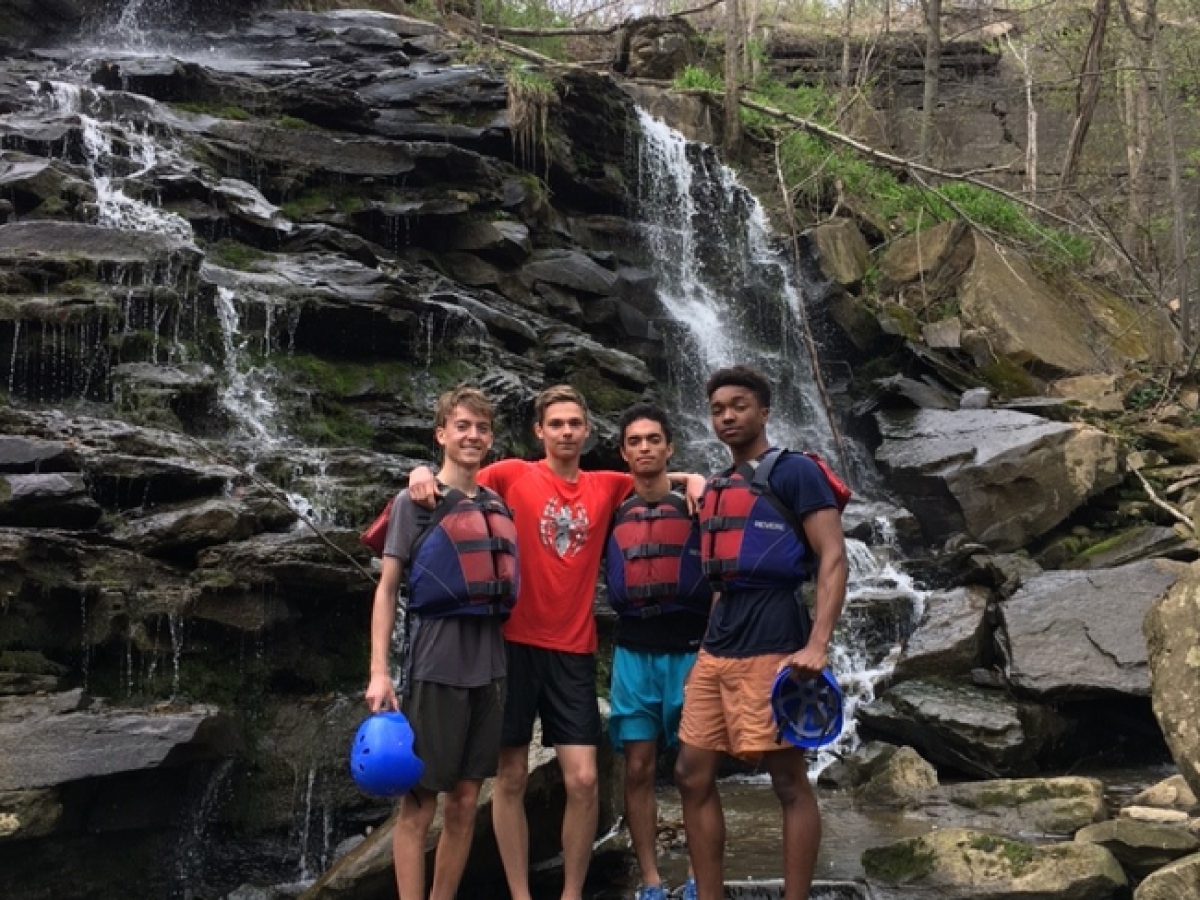 a group of people standing next to a waterfall