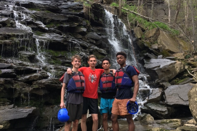 a group of people standing next to a waterfall