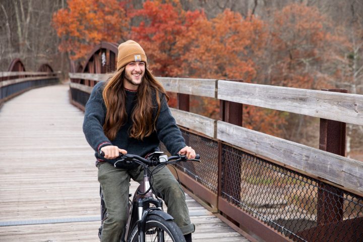 a man riding a bicycle next to a fence