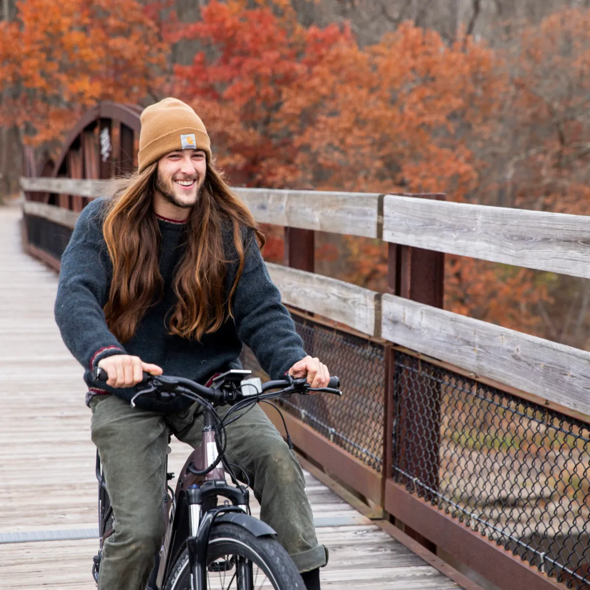 a man riding a bicycle next to a fence
