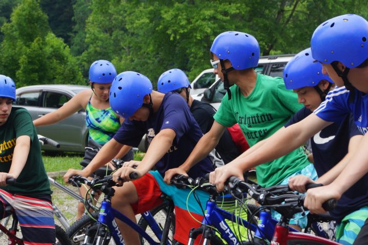 a little boy wearing a helmet and riding a bicycle