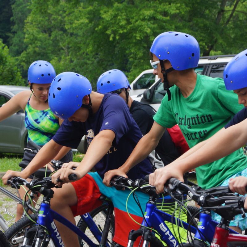 a little boy wearing a helmet and riding a bicycle