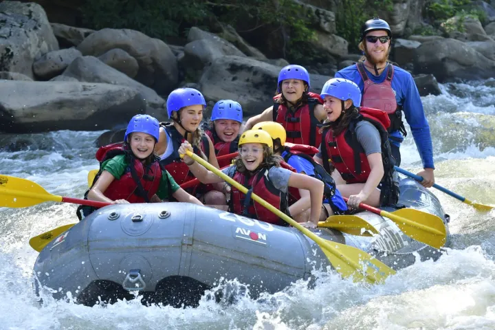 a group of people riding skis on a raft in the water