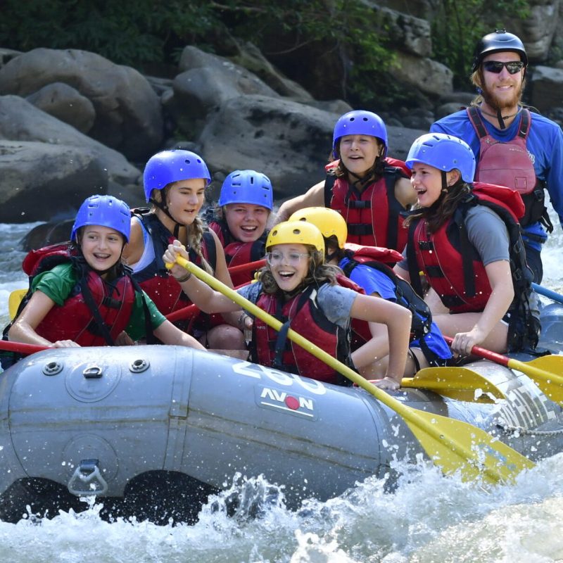 a group of people riding skis on a raft in the water