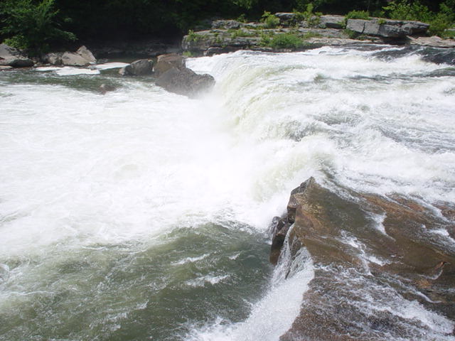 Rushing water over rocks in a flowing river.